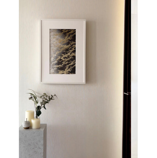 白い壁に飾られた帯を切らずに飾る額縁と霞柄の帯