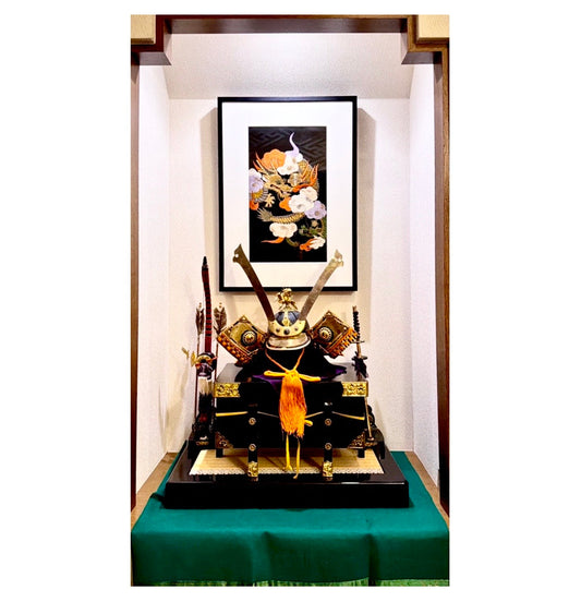 アンティークの帯を飾る「切らない帯額装」のリメイク実例。床の間の兜飾りとともに展示された黒地の豪華な和風アートフレーム。