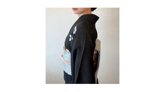 黒い着物に水色の帯を合わせた着姿。着物や帯をそのまま活かし、和装の美しさを楽しむコーディネート。