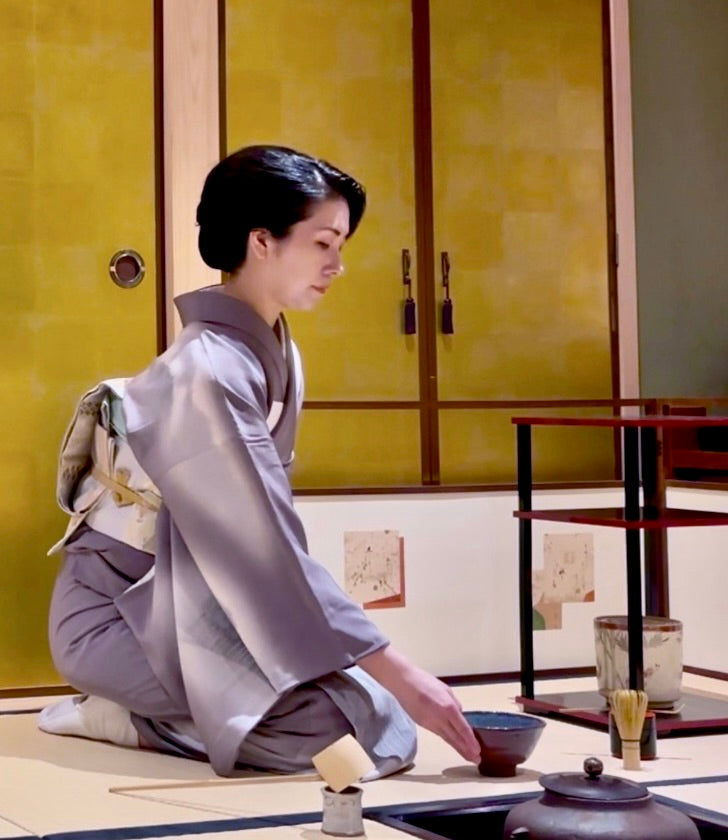茶室で着物を着て茶道を行う女性。日本の伝統文化を大切にするSAKURA JAPANは、帯を切らずに額縁に入れて飾る新しいインテリアの楽しみ方を提案しています。