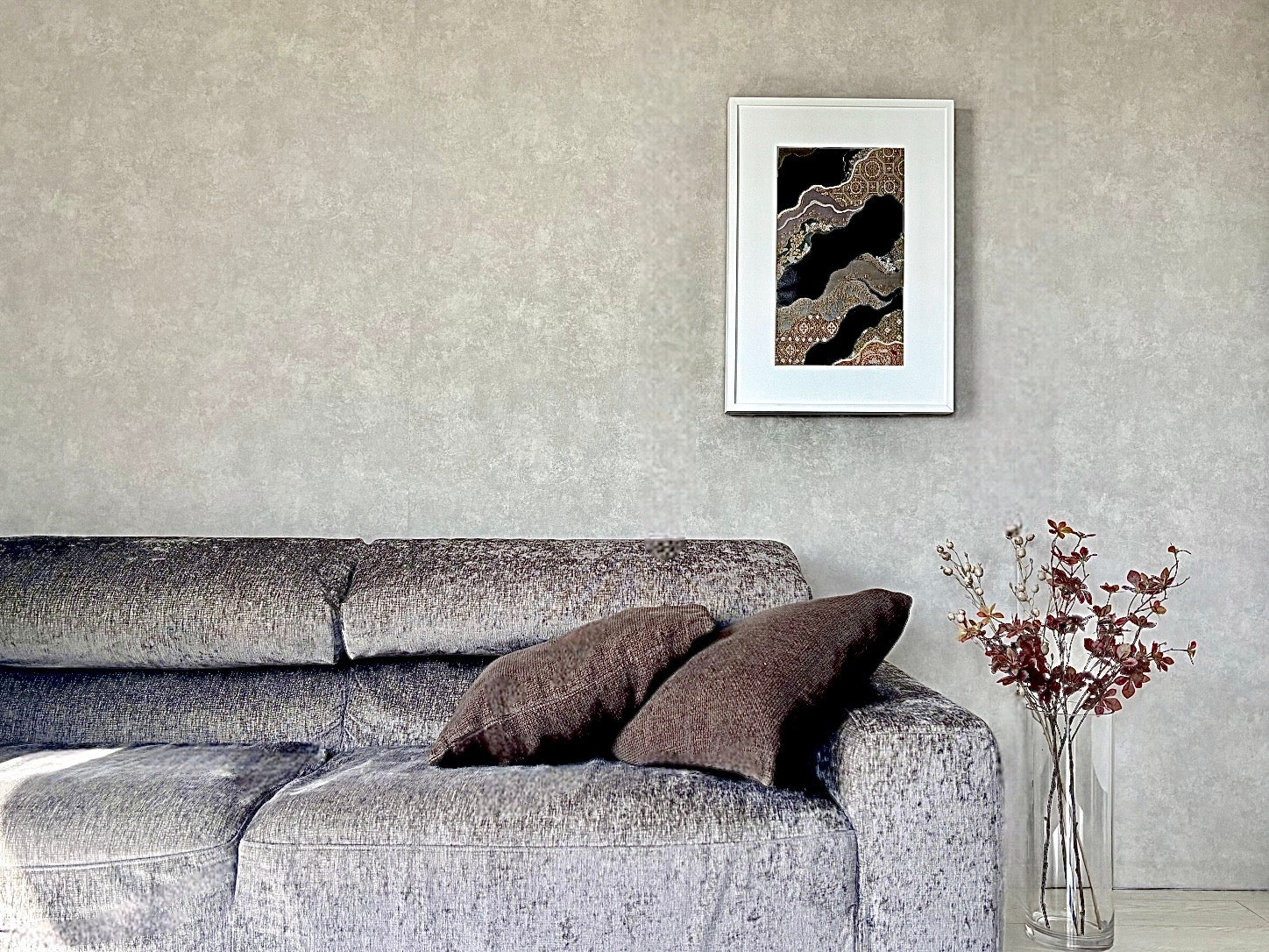 帯を切らずに飾る額縁をリビングのソファの後ろにインテリアとして飾る